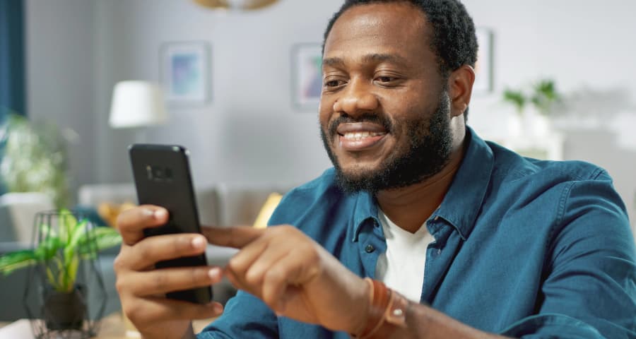 Man sitting down using a home security app on his phone